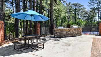 a patio with an umbrella and table with chairs at 300 Riverside Apartments, Austell, Georgia